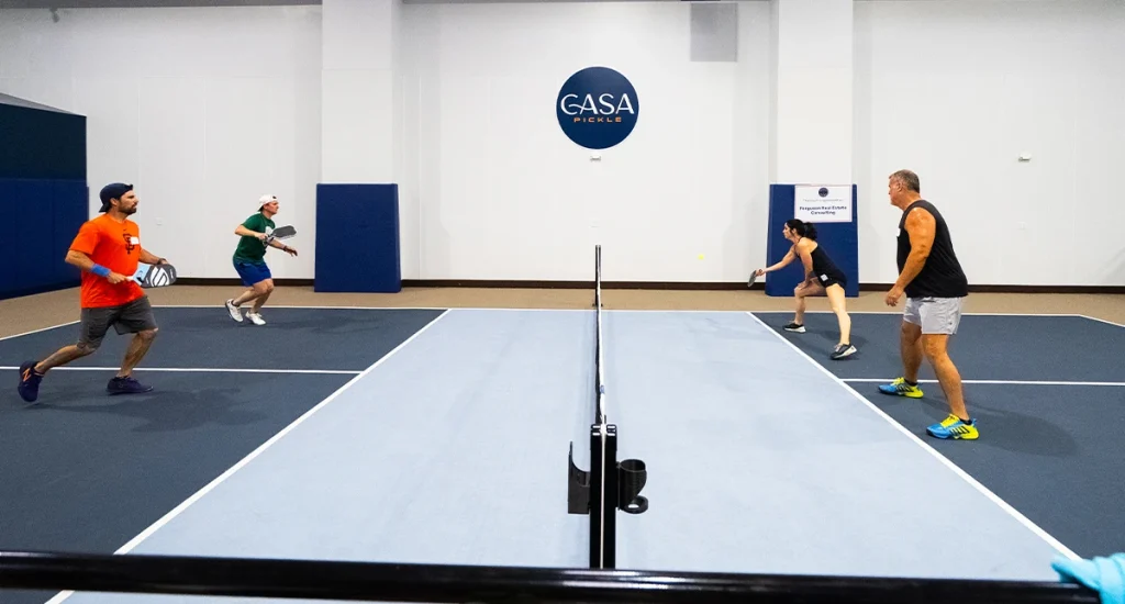 Four people playing indoor pickleball.